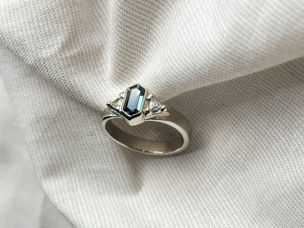 white gold ring set with diamonds and an emerald cut gemstone